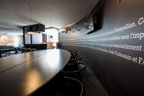 a conference room with a long table and chairs at PoMo Hôtel & Restaurant in Échirolles