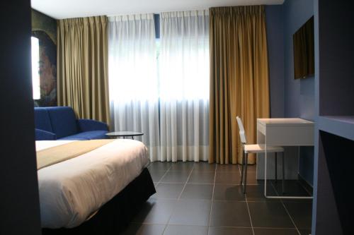 a bedroom with a bed and a desk and a window at Hotel Indiana in Pinto
