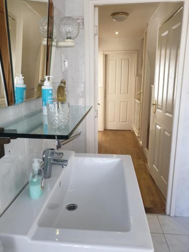 a bathroom with a white sink and a mirror at Tamar 2 in Katwijk aan Zee