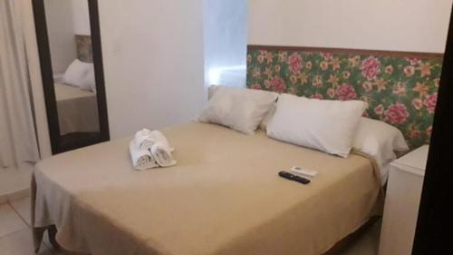 a bed with towels and a remote control on it at Pousada Boa Vida in Maceió