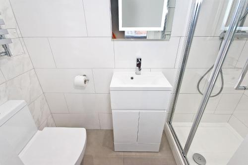 a white bathroom with a toilet and a sink at Interlude House A by City Living London in London