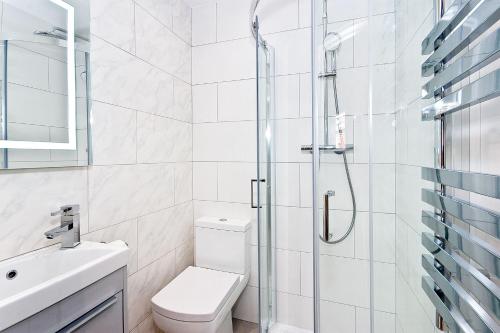 a bathroom with a shower and a toilet and a sink at Interlude House C by City Living London in London