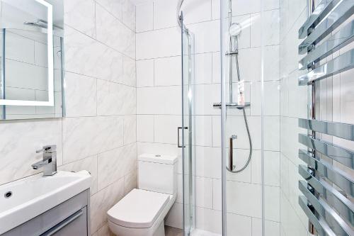 uma casa de banho com um chuveiro, um WC e um lavatório. em Interlude House C by City Living London em Londres