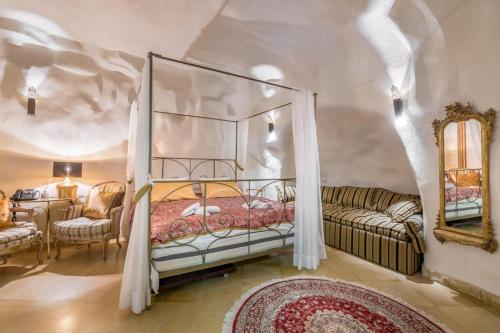 Western Wall Luxury House في القدس: غرفة نوم مع سرير مظلة وأريكة