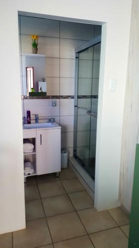 a bathroom with a glass shower and a sink at Rustverseker Self Catering Accommodation in George