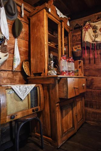 a room with a wooden cabin with a cabinet and utensils at Etno selo Moj Zavičaj in Gornji Milanovac