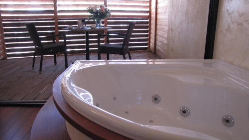 uma banheira num quarto com uma mesa e cadeiras em Ile du Gua Suites em Narbonne