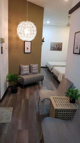 a living room with a bed and a chandelier at Rooms only @KKB in Kuala Kubu Baharu
