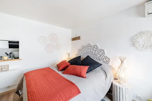 a white bedroom with a bed with red pillows at Studio centre ville avec parking in Sanary-sur-Mer