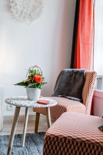 a living room with a table and a chair and a plant at Studio centre ville avec parking in Sanary-sur-Mer