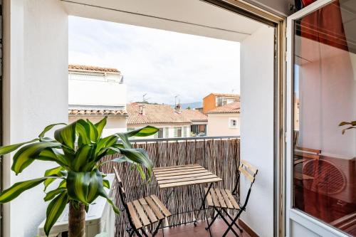 a balcony with a table and chairs and a plant at Studio centre ville avec parking in Sanary-sur-Mer