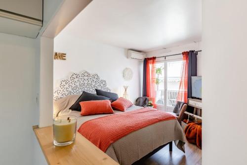 een slaapkamer met een bed met een rode deken bij Studio centre ville avec parking in Sanary-sur-Mer