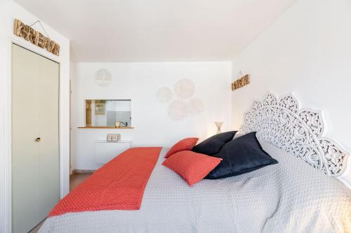 a bedroom with a bed with red and black pillows at Studio centre ville avec parking in Sanary-sur-Mer