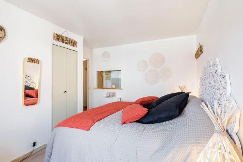 a bedroom with a bed with red and black pillows at Studio centre ville avec parking in Sanary-sur-Mer