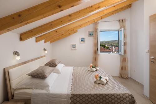 a bedroom with a large white bed and a window at Villa Bravura Milna in Milna