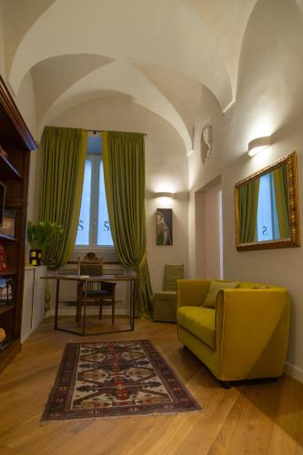 a living room with a yellow couch and a table at Dimora Storica Lo Svevo in Iesi