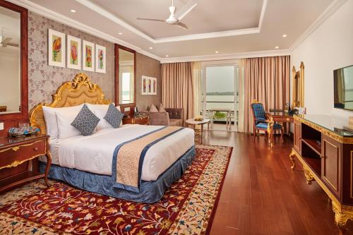 a bedroom with a king sized bed and a desk at MAYFAIR Lake Resort in Raipur