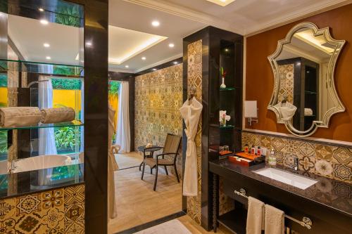 W łazience znajduje się umywalka i lustro. w obiekcie MAYFAIR Lake Resort w mieście Raipur
