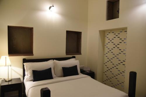 a bedroom with a bed with two night stands and two lamps at Baijoo Niwas in Jodhpur