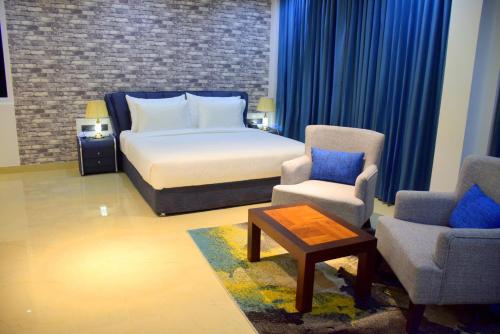 a bedroom with a bed and two chairs and a table at Ruvisha Beach Hotel in Negombo