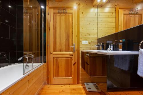 uma casa de banho com uma banheira, um lavatório e um chuveiro em Jacuzzi & Sauna | Chalet Teremok em La Tzoumaz