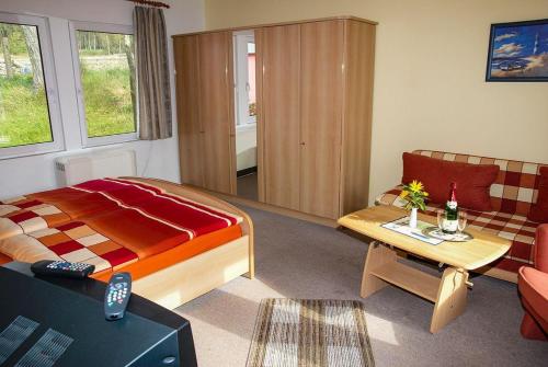 ein Schlafzimmer mit einem Bett, einem Tisch und einem Sofa in der Unterkunft Doppelzimmer mit Gemeinschaftsbad in Groß Banzelvitz