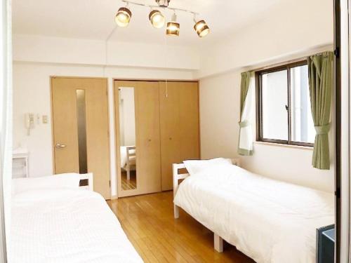 a bedroom with two beds and a mirror at ピオーレ大手門402 in Fukuoka