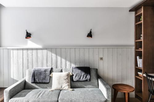 uma sala de estar com um sofá cinzento e duas luzes em Appartement La Vallée Blanche avec parking gratuit em Chamonix-Mont-Blanc