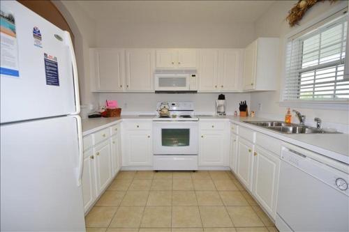 a kitchen with white cabinets and a white refrigerator at 1633 Ironwood Condo in Myrtle Beach