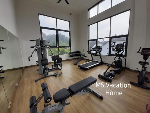 a gym with treadmills and ellipticals in a room with windows at MS Vacation Home (Muslim Homestay) in Cameron Highlands