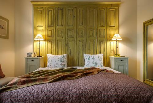 a bedroom with a large bed with two lamps at Herba-ház in Dánszentmiklós