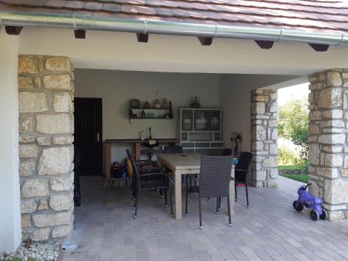 a patio with a table and chairs in a house at Kálium Vendégház in Mindszentkálla