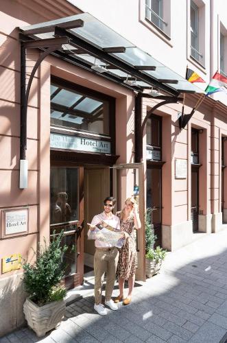 a man and a woman standing outside of a hotel at Three Corners Hotel Art in Budapest