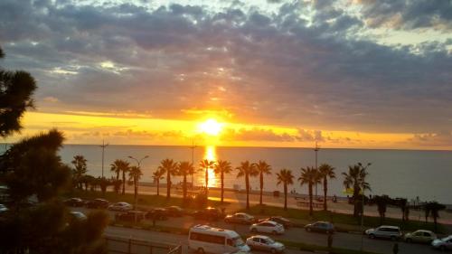 Sonnenuntergang über einem Parkplatz mit Palmen in der Unterkunft Selazir in Batumi