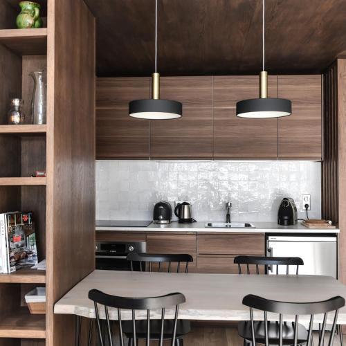 une cuisine avec des armoires en bois et une table avec des chaises dans l'établissement Appartement La Vallée Blanche avec parking gratuit, à Chamonix-Mont-Blanc