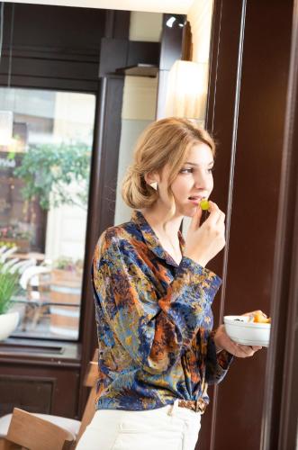 a woman eating a bowl of food at Three Corners Hotel Art in Budapest