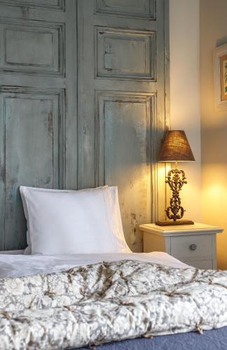a bed with a white pillow and a lamp on a table at Herba-ház in Dánszentmiklós