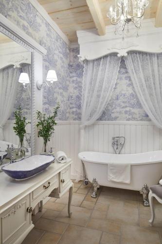 a bathroom with a tub and a large mirror at Osada Maruszyna in Szaflary