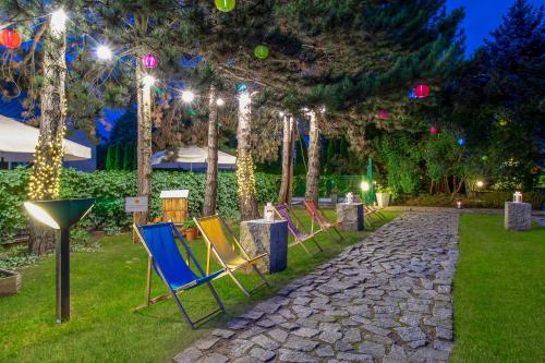 a row of lawn chairs in a garden at night at Novotel Warszawa Airport in Warsaw