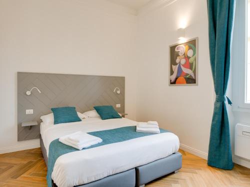 a bedroom with a large bed with blue pillows at The Right Place - Guest House in Rome
