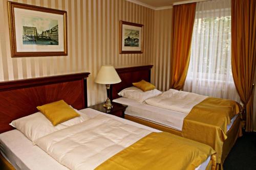 a hotel room with two beds and a window at Penzion Mova in Kadaň