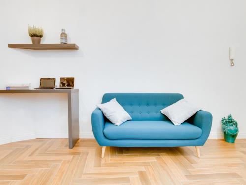 a blue couch in a living room with a table at The Right Place - Guest House in Rome