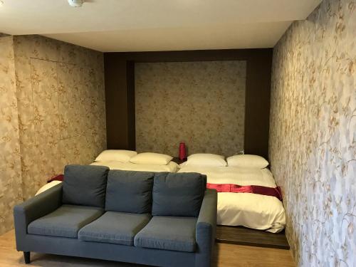 a living room with a bed and a couch at Every Day Hot Spring Hotel in Jiaoxi