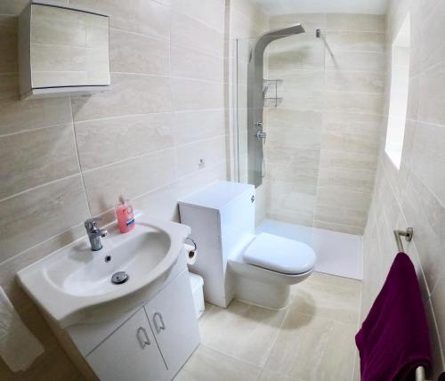 a white bathroom with a toilet and a sink at Empress Select Holiday Flats in Blackpool