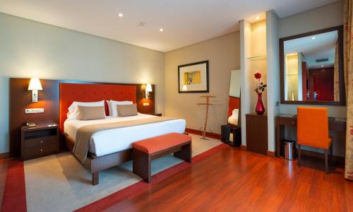 a hotel room with a bed and a table at Gran Hotel Attica21 Las Rozas in Las Rozas de Madrid