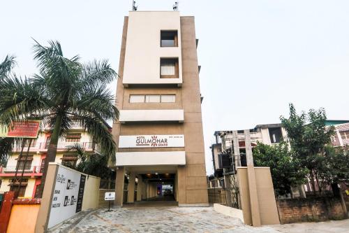 ein Gebäude mit einer Palme davor in der Unterkunft Hotel Gulmohar Grand in Jorhat