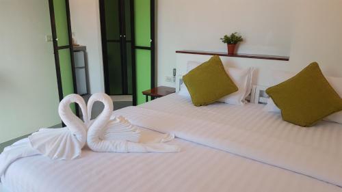 two white swans sitting on top of a bed at Good Place in Koh Tao