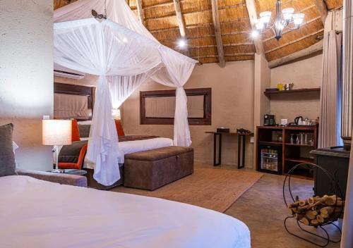 a bedroom with a bed with mosquito netting at aha Makalali Private Game Lodge in Makalali Game Reserve