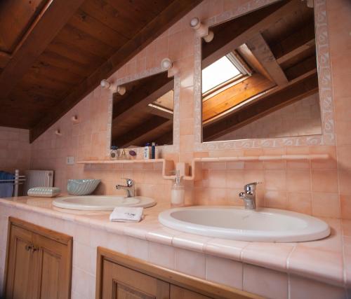 une salle de bain avec deux lavabos et un miroir dans l'établissement B&B Da Time, à Vittorio Veneto