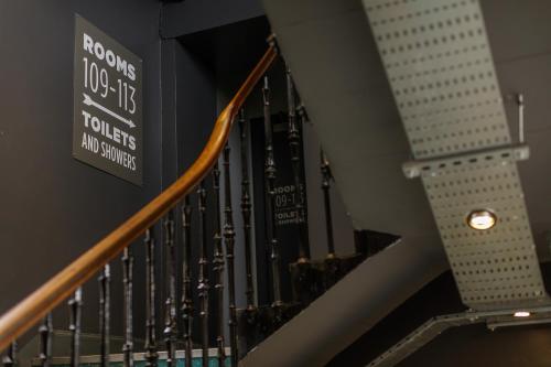 a staircase in a building with a sign on the wall at Kick Ass Greyfriars (18+) in Edinburgh